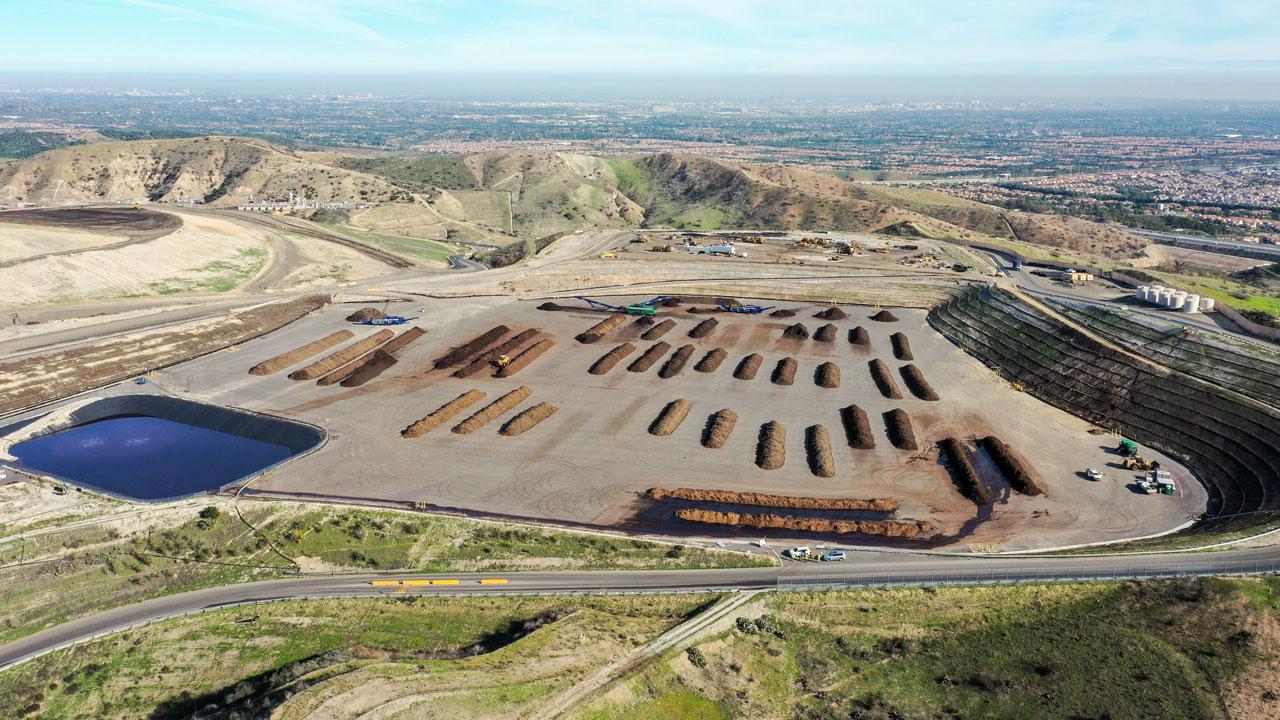 Aerial view of a organic waste composting facility producing soil amendment materials for agriculture with a blue sky in the background