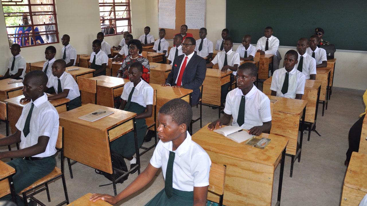 Malawi President and First Lady sit in a SEED Classroom in Mkanga, Salima among other students at their desks